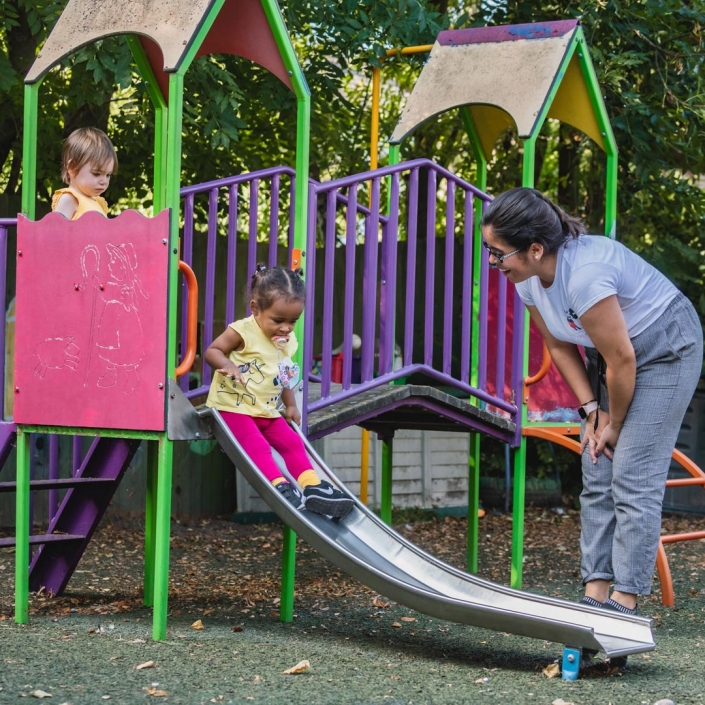 Children having fun on the climbing equipment and slide, at Little Cedars nursery, Streatham.