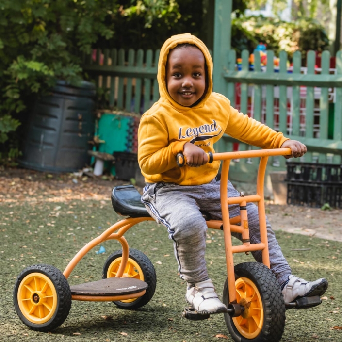 A wonderful tricycle being enjoyed by a young child at Little Cedars Nursery.