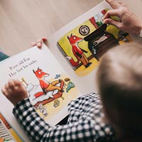 A young child reads with a parent