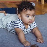 Try putting the baby in a prone position (on their tummy) on, say, a clean blanket or rug.