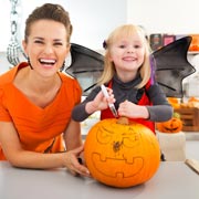 Family preparing a Jack-O'-Lantern pumpkin.