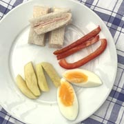 Sliced hard-boiled egg, apple and pepper fingers, and finger-shaped sandwiches.