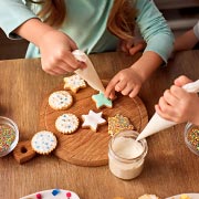 Applying icing and sprinkles to cookies or biscuits makes for a fun and tasty decorating activity.